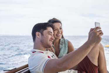 Happy couple on a boat trip taking a selfie - WESTF22221