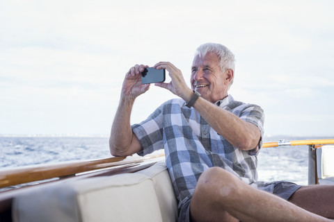 Älterer Mann auf einer Bootsfahrt, der ein Foto macht, lizenzfreies Stockfoto