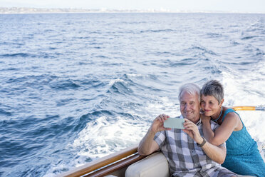 Smiling couple on a boat trip taking a selfie - WESTF22237