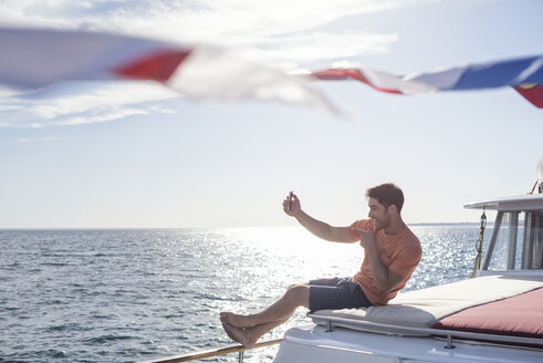 Junger Mann auf einem Boot posiert für ein Selfie - WESTF22264