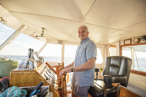 Selbstbewusster älterer Mann am Steuer eines Bootes - WESTF22291