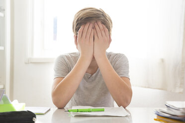 Boy doing homework covering his face - LVF05671