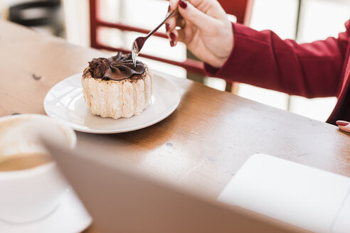 Junge Frau genießt Kuchen in einem Cafe - UUF09435