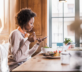 Young woman using cell phone in a cafe - UUF09469