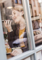 Junge Frau benutzt Mobiltelefon in einem Café - UUF09474