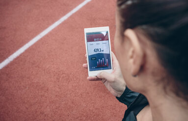 Sportler schaut auf sein Smartphone mit Trainingsdaten auf dem Display - DAPF00500