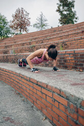 Woman doing pushups on stairs - DAPF00501