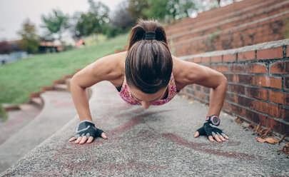 Woman doing pushups on stairs - DAPF00502