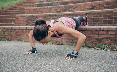 Woman doing pushups on stairs - DAPF00503