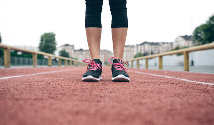 Woman standing on tartan track - DAPF00518