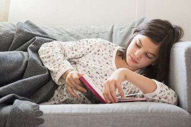 Mädchen liegt auf der Couch und liest ein Buch - LVF05677