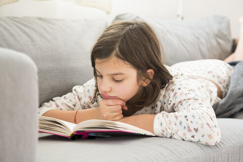 Girl lying on the couch reading a book - LVF05678