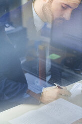 Young businessman working in office - ZEDF00453