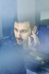 Young businessman in office looking out of window - ZEDF00454