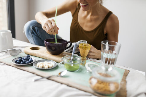 Woman preparing matcha latte at home - VABF00880