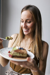 Woman eating vegan matcha cake - VABF00894