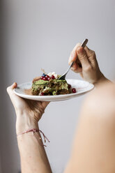 Woman eating vegan matcha cake - VABF00895