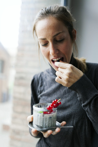 Junge Frau isst Chia-Pudding, lizenzfreies Stockfoto