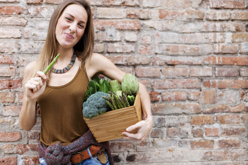 Smiling woman holding basket with fresh vegetables - VABF00907