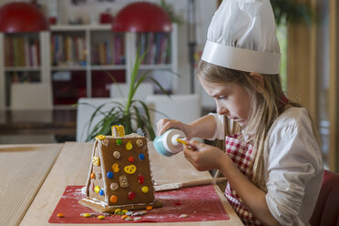 Mädchen garniert Pfefferkuchenhaus - SARF03089