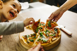 Vater und Sohn heben Pizzastücke auf - JRFF01096