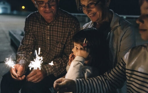 Großeltern mit Enkelkindern, die nachts Wunderkerzen halten - DAPF00527