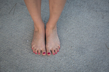 Women's feet on grey ground - JUNF00710