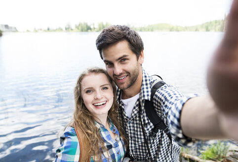Junges Paar auf einer Wanderung an einem See macht ein Selfie - HAPF01180