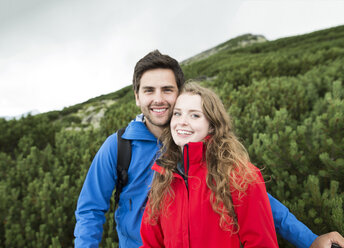 Porträt eines lächelnden jungen Paares auf einer Wandertour - HAPF01201