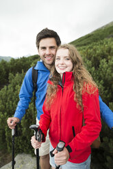 Porträt eines lächelnden jungen Paares auf einer Wandertour - HAPF01202