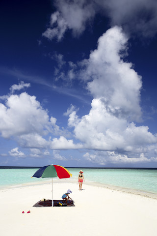 Malediven, Gulhi, Mutter und Tochter auf einer Sandbank im seichten Wasser, lizenzfreies Stockfoto