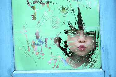 Mädchen schaut durch das Glas eines alten Fensters - DSGF01255