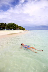 Maldives, Gulhi, woman floating in shallow water - DSGF01257