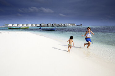 Malediven, Guraidhoo, Mutter und Tochter spielen am Strand - DSGF01262