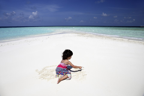 Maldives, girl on beach at shallow water stock photo