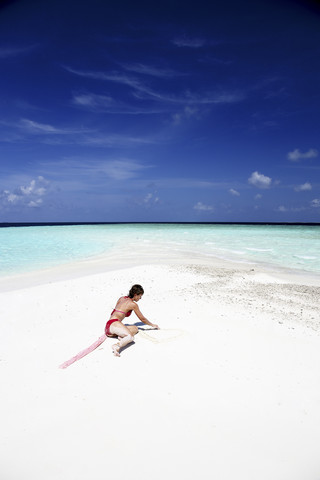 Maldives, woman on beach at shallow water stock photo