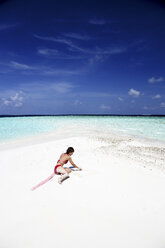 Maldives, woman on beach at shallow water - DSGF01270