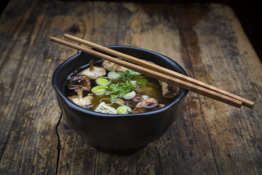 Bowl of miso soup with organic tofu, shitake mushrooms, leek and parsley on dark wood - LVF05699