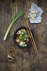 Schale Miso-Suppe mit Bio-Tofu, Shitake-Pilzen, Lauch und Petersilie auf dunklem Holz - LVF05700