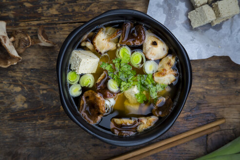 Schale Miso-Suppe mit Bio-Tofu, Shitake-Pilzen, Lauch und Petersilie auf dunklem Holz - LVF05701