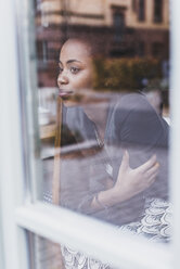 Young woman in a cafe looking out of window - UUF09487