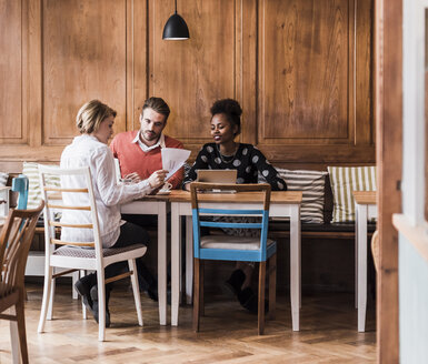 Drei junge Leute bei einem Treffen in einem Café - UUF09502