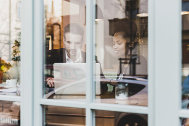 Young businessman and woman using laptop in a cafe - UUF09526