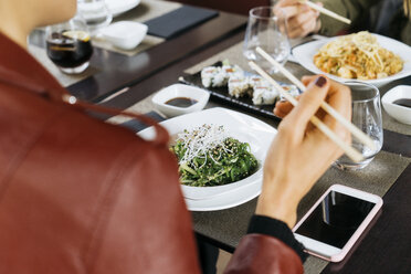 Freunde essen zusammen in einem Restaurant, Teilansicht - KKAF00174