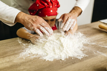 Father and son kneading dough together - JRFF01098