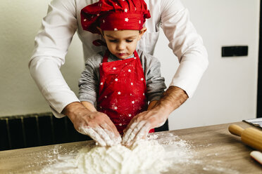 Father and son kneading dough together - JRFF01101