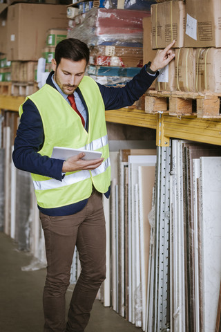 Mann im Lager, der den Bestand überwacht, lizenzfreies Stockfoto