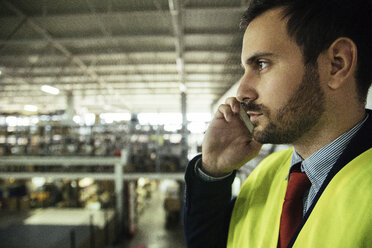 Man on cell phone in factory - ZEDF00467