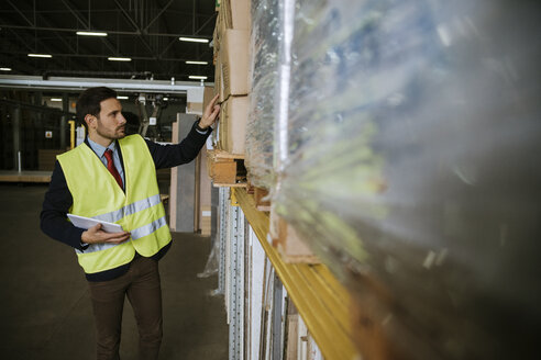 Man in warehouse supervising stock - ZEDF00474