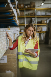 Woman in warehouse supervising stock - ZEDF00475